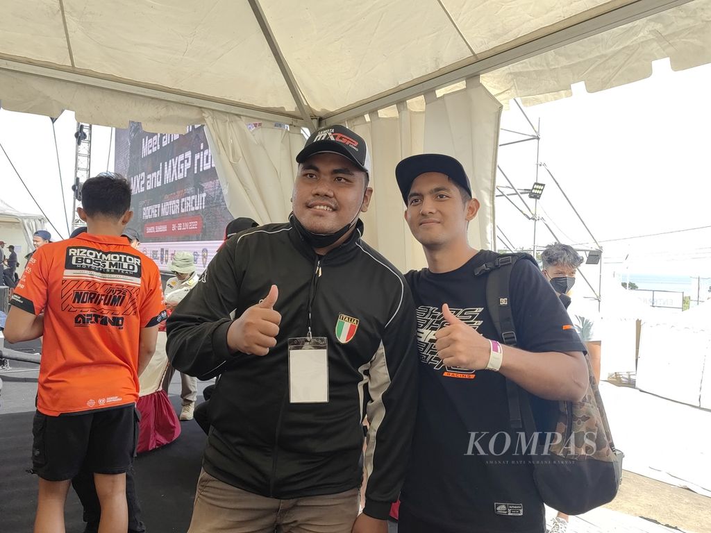 Pebalap Indonesia, Farhan Hendra Fahrodjie (kanan), melayani foto bersama dengan penggemarnya di kawasan Sirkuit Samota, Sumbawa, Nusa Tenggara Barat, Jumat (24/6/2022). Farhan akan bersaing di kelas utama MXGP.