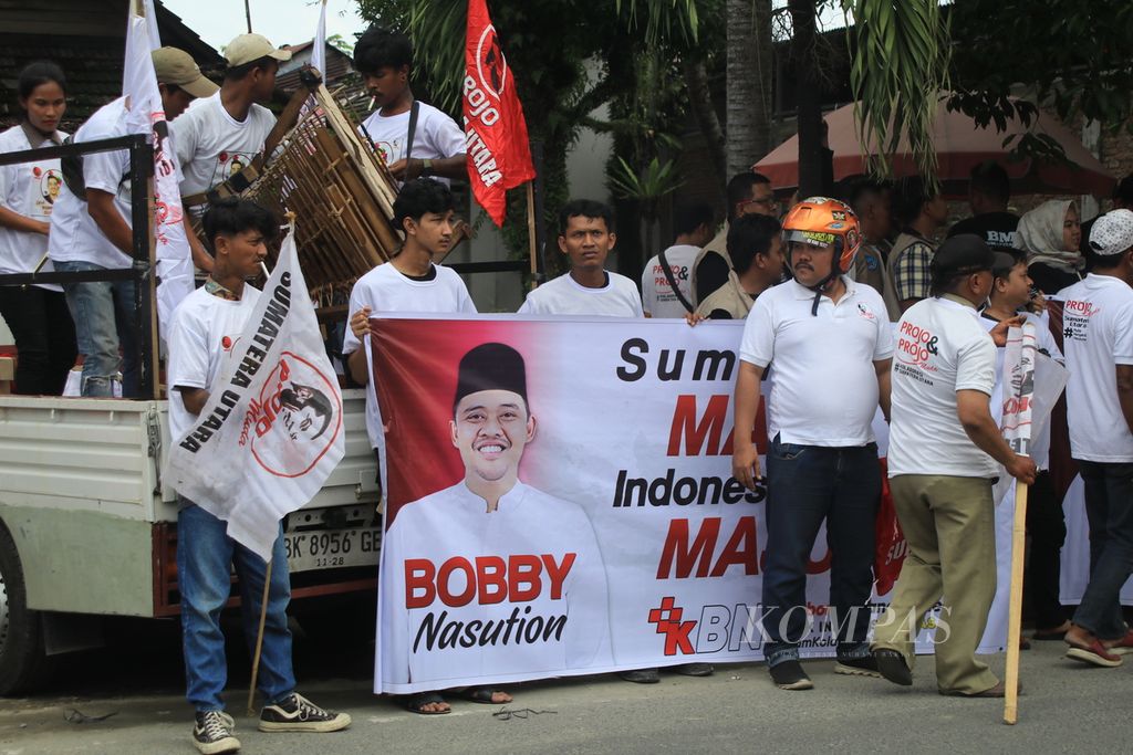 Para pendukung membawa spanduk Bobby Afif Nasution dan Surya yang mendaftar sebagai bakal calon gubernur dan wakil gubernur Sumatera Utara ke Komisi Pemilihan Umum Provinsi Sumatera Utara, di Medan, Rabu (28/8/2024). 