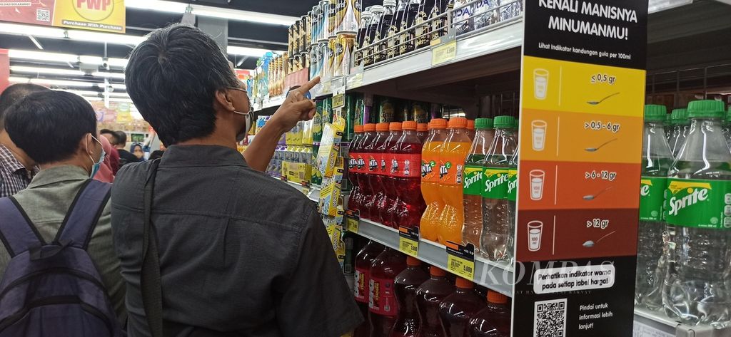 Seorang pelanggan memilih produk minuman berpemanis dalam kemasan yang dijual di gerai Superindo, Tangerang, Banten, akhir Januari 2023.