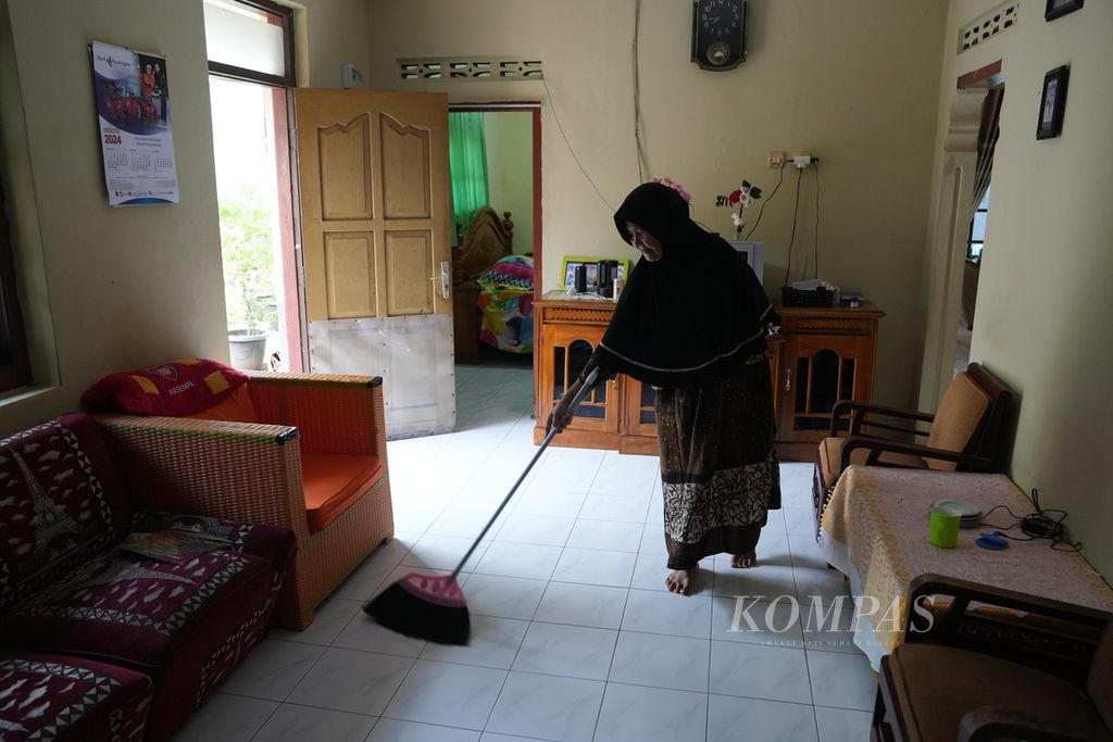 Kumairah (70) menyapu rumahnya di Desa Cibuntu, Kecamatan Pasawahan, Kabupaten Kuningan, Jawa Barat, Kamis (2/5/2024). Ada 70 rumah warga yang dijadikan penginapan di desa wisata tersebut.  