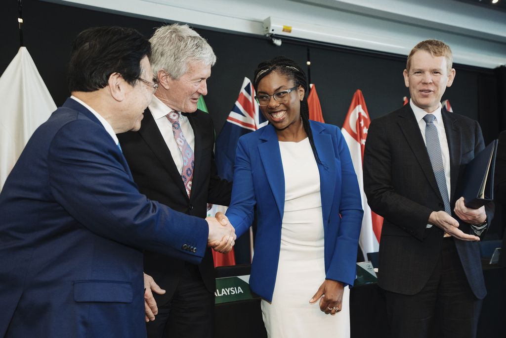 Menteri Perdagangan Inggris Kemi Badenoch (kedua dari kanan) berjabat tangan dengan Menteri Revitalisasi Perekonomian Jepang Shigeyuki Goto (kiri), disaksikan Menteri Perdagangan dan Pertumbuhan Ekspor Selandia Baru Damien O'Connor (kedua dari kiri), dan Perdana Menteri Selandia Baru Chris Hipkins dalam pertemuan tingkat menteri Perjanjian Komprehensif dan Progresif Kemitraan Trans-Pasifik (CPTPP) di Auckland, Selandia Baru, Minggu (16/7/2023). 