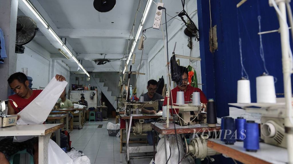 Pekerja merampungkan pembuatan pakaian untuk Alat Pelindung Diri tenaga medis di Pusat Industri Kecil, Penggilingan, Jakarta Timur, Selasa (24/3/2020). 