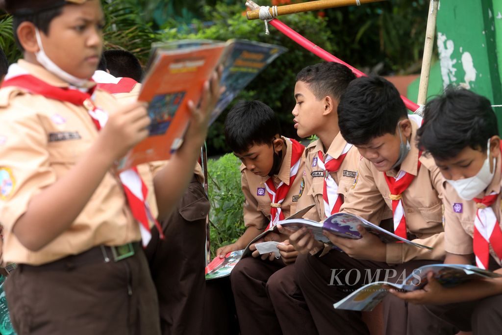 Anak-anak membaca buku yang dibawa motor layanan perpustakaan keliling Sudin Perpustakaan dan Kearsipan (Sudin Pusip) di SDN 04 Pondok Bambu, Jakarta, Rabu (26/10/2022).