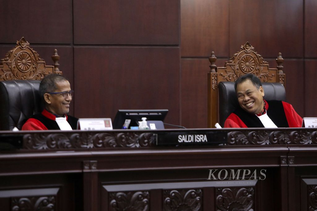 Hakim Konstitusi Saldi Isra berbincang dengan Arief Hidayat (kanan), saat persidangan pengujian materiil Kitab Undang-Undang Hukum Perdata di Mahkamah Konstitusi, Jakarta, Senin (13/3/2023). 