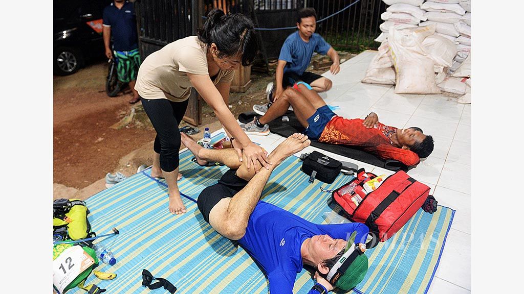 Pelari  Oktavianus Quaasalmy (biru) dan Matheos Berhitu (merah) mendapatkan penanganan dari fisioterapis saat beristirahat di Kilometer 180 dalam lomba lari maraton ultra Lintas Sumbawa 320K di Desa Gapit, Kecamatan Empang, Sumbawa, Nusa Tenggara Barat, Kamis (5/4/2018).