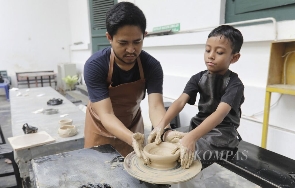 Seorang ayah mendampingi anaknya belajar membuat tembikar di Museum Seni Rupa dan Keramik saat libur Idul Adha, Selasa (18/6/2024). Belajar membuat tembikar menjadi aktivitas yang dapat meningkatkan kreativitas anak. 