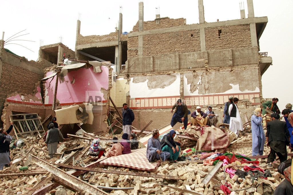 Warga melihat bangunan yang hancur di dekat mobil yang meledak di Provinsi Herat, Afghanistan, Sabtu (13/3/2021). (AP Photo/Hamed Sarfarazi)