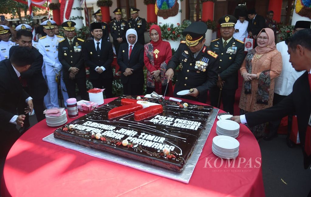 Kapolda Jawa Timur Inspektur Jenderal Polisi Toni Harmanto memotong kue untuk diberikan ke Gubernur Jawa Timur Khofifah Indar Parawansa seusai upacara Peringatan Hari Bhayangkara ke-77 di Gedung Negara Grahadi. Surabaya, Sabtu, (1/7/2023). 