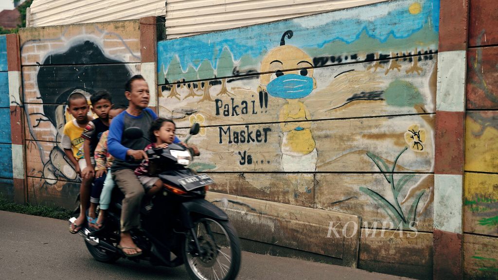 Warga melintasi mural ajakan untuk tetap mengenakan masker di Menteng Atas, Setiabudi, Jakarta Selatan, Kamis (16/12/2021). 