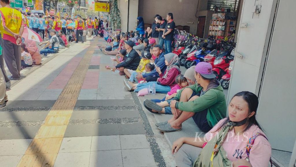 Para pengunjung antusias menonton kirab Jut Bio dengan duduk di depan deretan toko di sepanjang kawasan Pecinan, Kota Magelang, Minggu (1/10/2023).