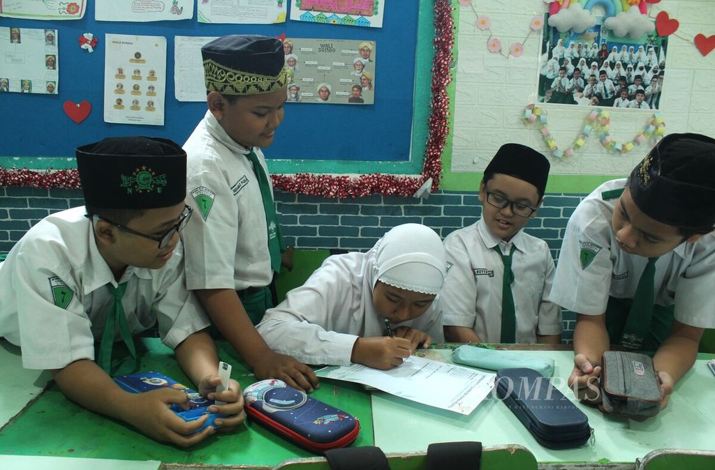 Siswa kelas VI Madrasah Ibtidaiyah Nahdlatul Ulama KH Mukmin, Sidoarjo, Jawa Timur, menyusun laporan kegiatan Proyek Penguatan Profil Pelajar Pancasila dan Profil Pelajar Rahmatan lil Alamin, Selasa (3/10/2023).