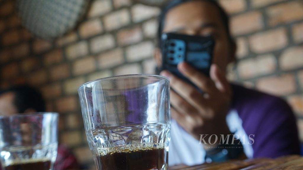 Segelas kopi arabika Semendo yang dinikmati oleh seorang pelanggan di Kedai Mung Kopi, Palembang, Sumatera Selatan, Minggu (31/7/2022). 