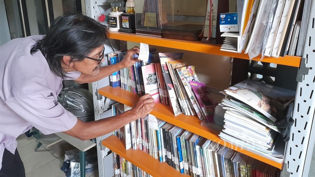 Bagas Sutoko menata koleksi buku di perpustakaannya di Desa Cempokomulyo, Kepanjen, Kabupaten Malang, Jawa Timur, Rabu (10/5/2023).