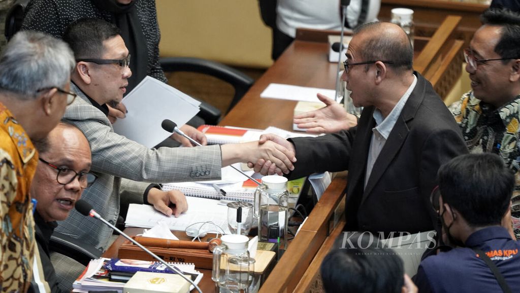 Chairman of Commission II Ahmad Doli Kurnia (left) shakes hands with Chairman of the General Election Commission Hasyim Asy'ari (right) at the building of the Indonesian Parliament, Jakarta, Tuesday (24/1/2024).