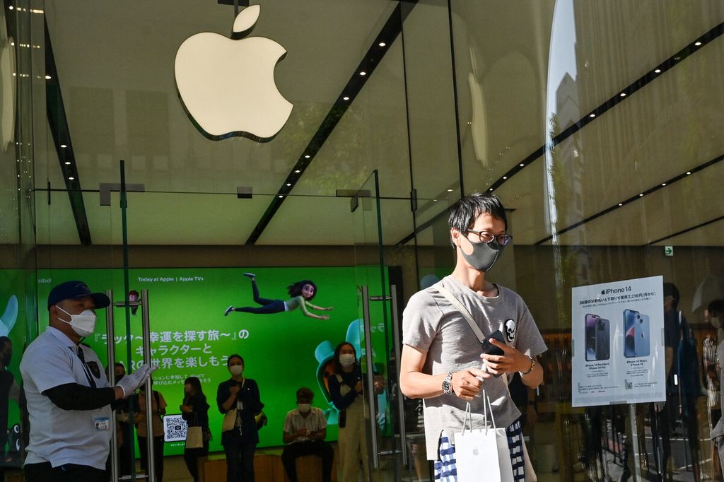 Seorang pelanggan meninggalkan toko Apple setelah mendapatkan produk yang dibelinya saat peluncuran iPhone 14 baru di Tokyo, Jepang, Jumat (16/9/2022). 