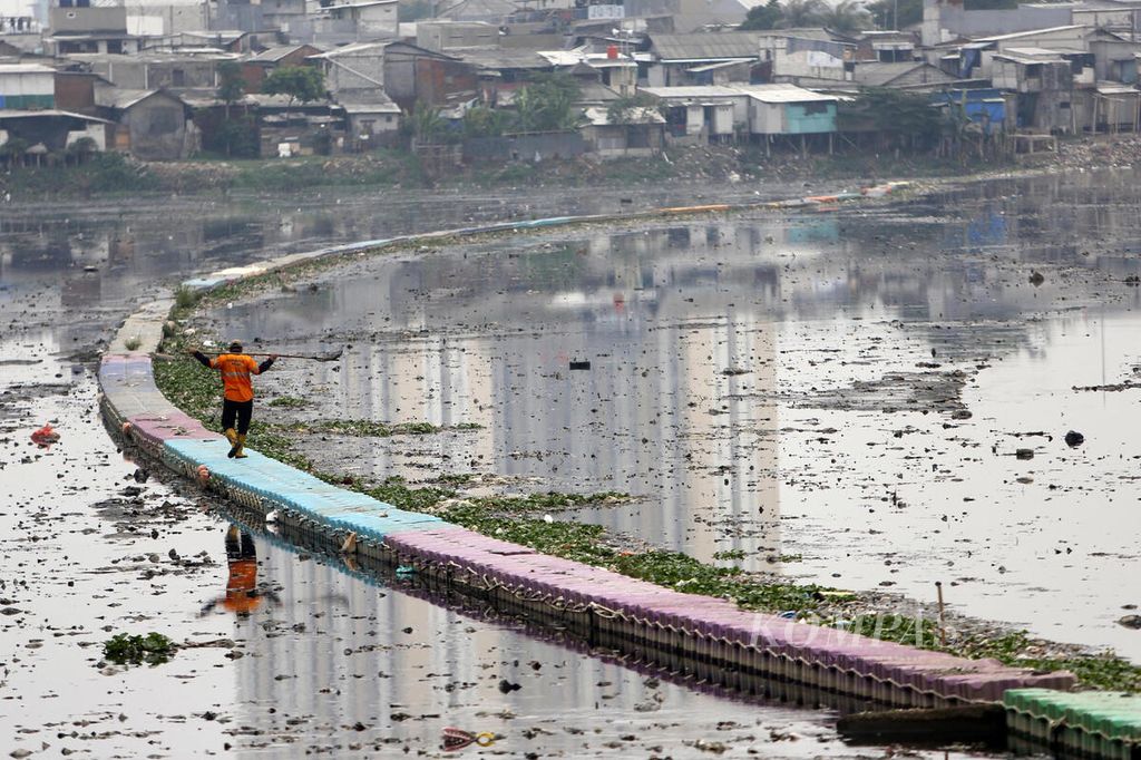 Petugas Badan Air Dinas Lingkungan Hidup Provinsi DKI Jakarta membersihkan Waduk Pluit, Jakarta Utara, dari sampah, yang sebagian telah selesai dikeruk lumpurnya, Kamis (7/12/2023).