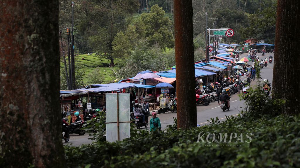 Parkir liar marak di tepi jalan sekitar kawasan kebun teh di Puncak, Kabupaten Bogor, Jawa Barat, saat libur akhir pekan, seperti pada Minggu (13/2/2022). 