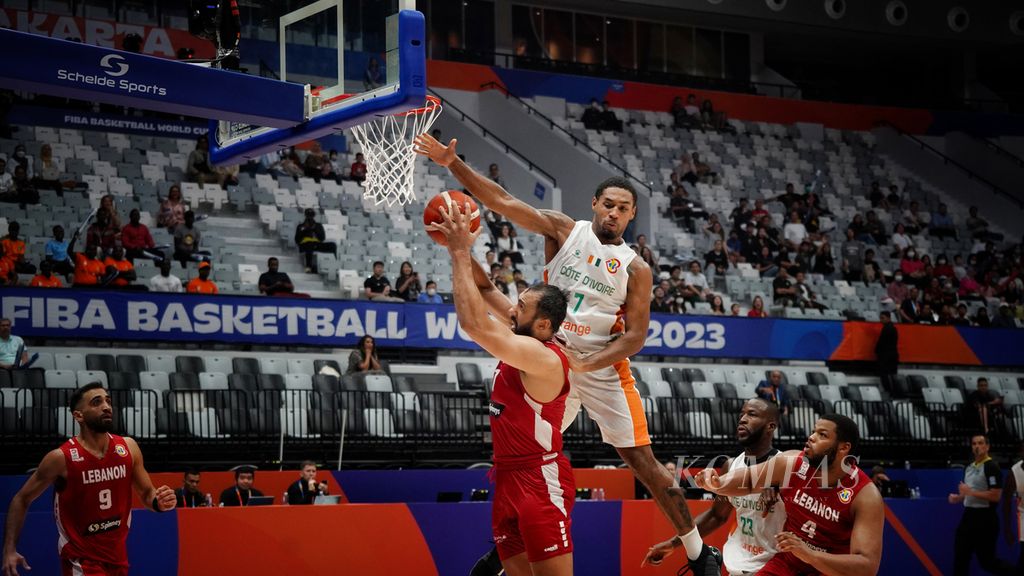 Pemain tim Pantai Gading, Maxence Dadiet, melompat untuk menghalangi pemain tim Lebanon, Ali Haidar, dalam laga kualifikasi Grup P yang memperebutkan klasifikasi peringkat dalam Piala Dunia FIBA 2023 di Stadion Indonesia Arena, Jakarta, Kamis (31/8/2023). Dalam laga ini, tim Lebanon mengalahkan tim Pantai Gading dengan skor 94-84. 