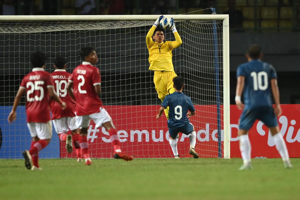Indonesia U-19 football team goalkeeper Cahya Supriadi (third right), catches the ball shot by Brunei Darussalam player Idzzaham Aleshahmezan (second right), in the preliminary match of Group A of the 2022 AFF U-19 Cup at Patriot Candrabhaga Stadium, Bekasi, Java West, Monday (4/7/2022).