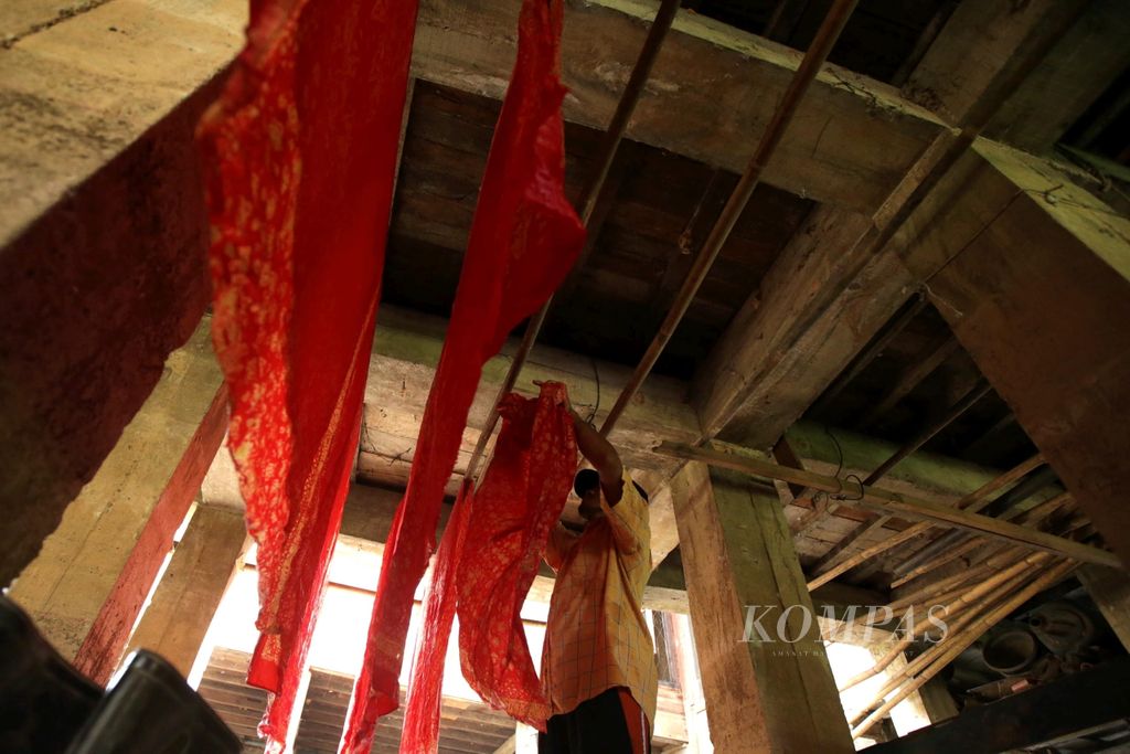 Pekerja menjemur kain batik setelah diberi pewarnaan di kolong ruang kerja Rumah Batik Azmiah di Kota Jambi, Rabu (8/6/2016).