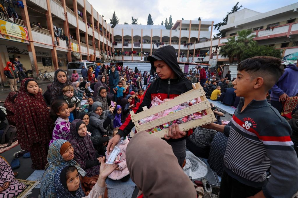 Anak-anak Palestina mendapat hadiah makanan setelah mereka mengikuti shalat Idul Fitri di Rafah, Jalur Gaza selatan, Rabu (10/4/2024). Israel melancarkan serangan mematikan terhadap keluarga Pemimpin Hamas Ismail Haniyeh saat Idul Fitri.