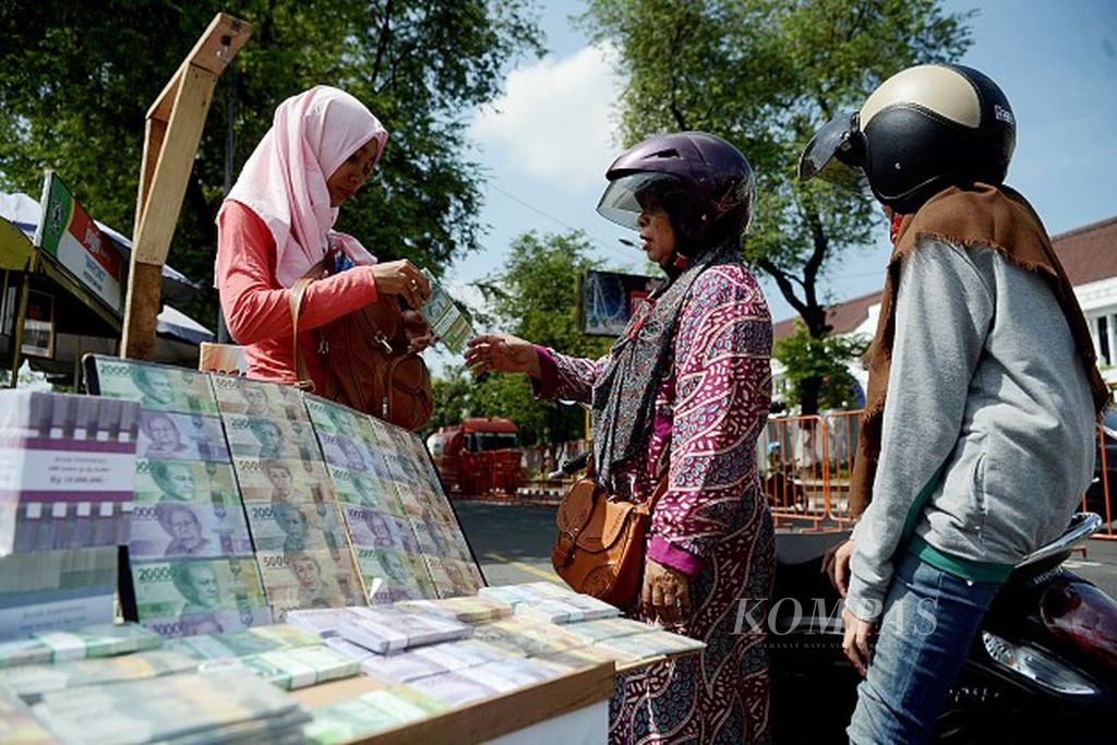Penjual jasa penukaran uang melayani konsumen di kawasan Titik Nol, Yogyakarta, Jumat (16/6). Menjelang Idul Fitri, warga mulai menukarkan uang ke pecahan lebih kecil untuk dibagikan saat Lebaran.