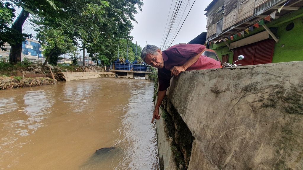 Warga menunjukkan kondisi tanggul yang rusak dan berlubang di pinggir Kali Baru, kawasan Hek, Kramat Jati, Jakarta Timur, Rabu (21/6/2023). 