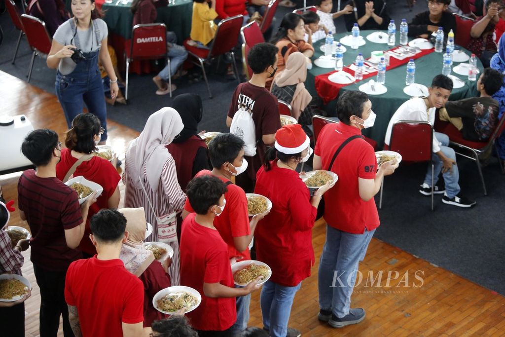 Para sukarelawan dari komunitas Domus Cordis melayani peserta Makan Siang Natal di Gedung Judo, Kelapa Gading, Jakarta Utara, Senin (25/12/2023). Makan Siang Natal ini diikuti oleh sekitar 580 warga kurang mampu dan penyandang disabilitas lintas agama di kawasan Jabodetabek.