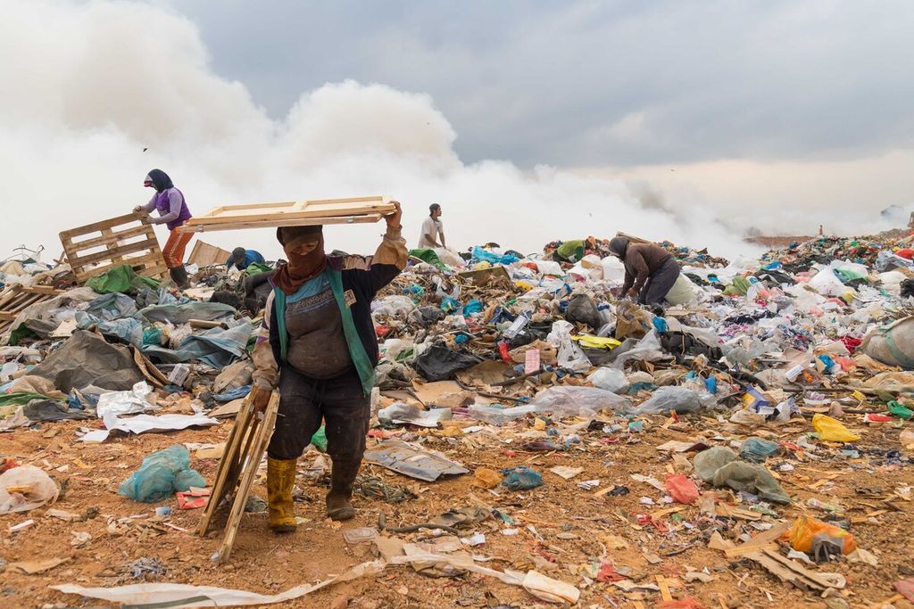 Sejumlah pemulung beradu cepat memilah sampah bernilai dari kejaran api yang melalap Tempat Pembuangan Akhir Punggur, Kota Batam, Kepulauan Riau, Selasa (16/2/2021).