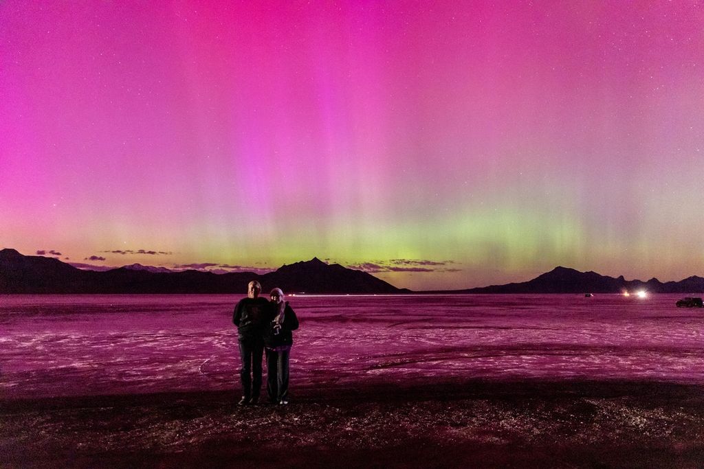 Orang-orang berfoto dengan latar belakang aurora di Wendover, Utah, Amerika Serikat, Jumat (10//5/2024). 