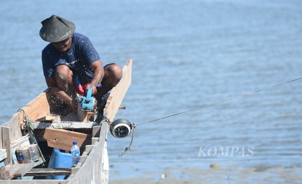 Nelayan memperbaiki perahunya di pesisir Kota Kendari, Sulawesi Tenggara, Jumat (9/8/2019). Kawasan tersebut belum digarap dengan maksimal walau mempunyai potensi wisata yang besar. 