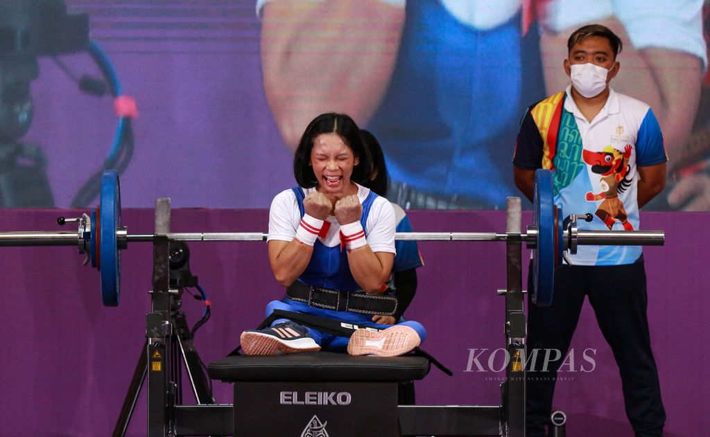 Ekspresi atlet angkat berat paralimpiade putri Indonesia, Eneng Paridah setelah berhasil melakukan angkatan 74 kilogram pada final angkat berat kelas 41 kilogram ASEAN Para Games 2022 di Surakarta, Jawa Tengah, Senin (1/8/2022). Eneng Paridah mempersembahkan medali emas.