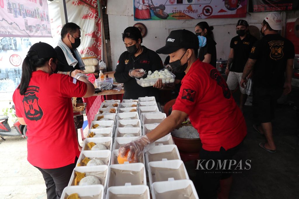 Sukarelawan perantauan asal Minahasa yang tergabung dalam Laskar Manguni membuka dapur umum bagi warga yang sedang menjalani isolasi mandiri ataupun yang terdampak PPKM darurat di kawasan Karet Semanggi, Setiabudi, Jakarta Selatan, Rabu (14/7/2021). Dalam satu hari rata-rata disiapkan sekitar 2.000 nasi kotak.