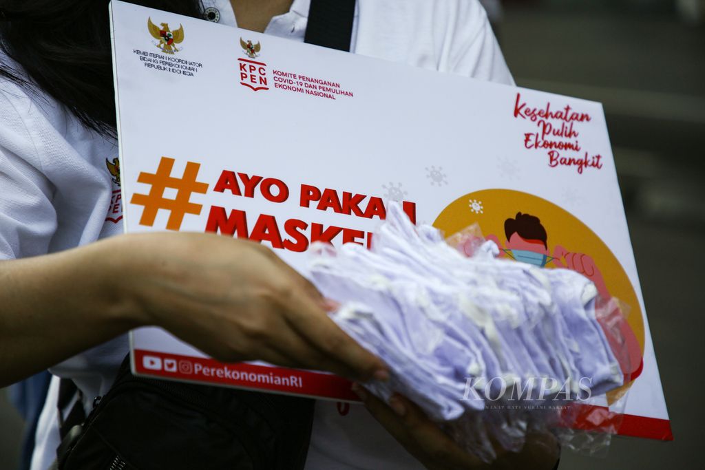 Sukarelawan membagikan masker gratis dalam acara Kampanye Nasional Jangan Kendor Disiplin Pakai Masker di Stadion Utama Gelora Bung Karno, Senayan, Jakarta, Minggu (30/8/2020).