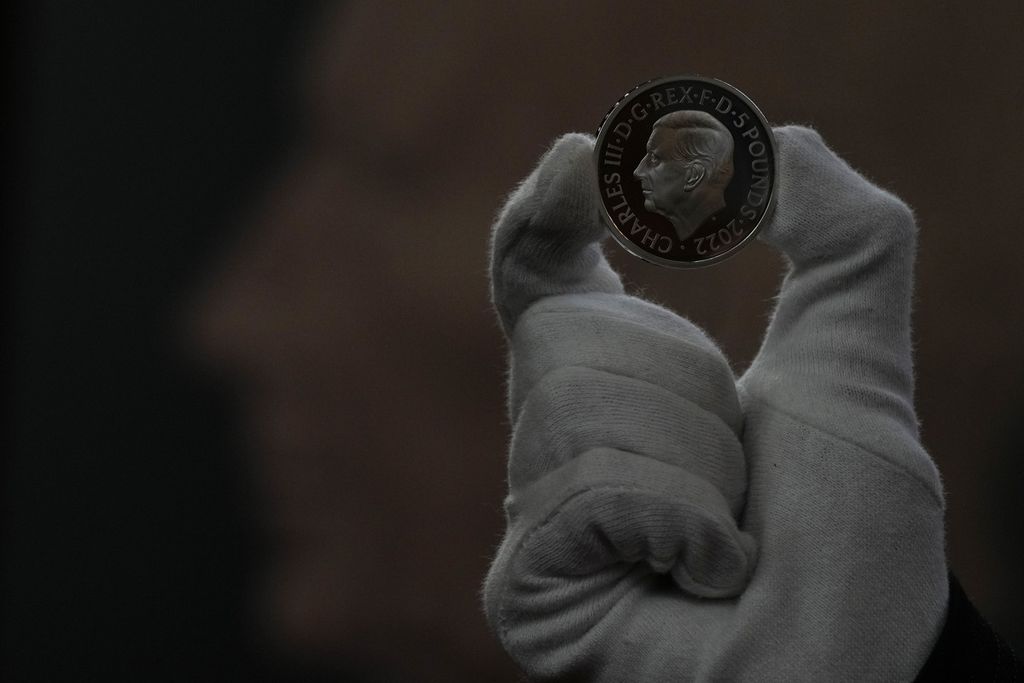 Staf Royal Mint memegang uang peringatan senilai 5 poundsterling bergambar potret Raja Charles III saat jumpa pers di London, Inggris, 29 September 2022. Koin ini akan menjadi koin pertama bergambar raja baru. 