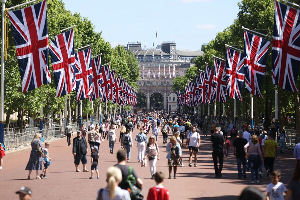 Warga berjalan di sepanjang The Mall yang didekorasi bendera Union Jack menjelang perayaan Platinum Jubilee, 70 tahun bertakhtanya Ratu Elizabeth II, di London, 22 Mei 2022. 