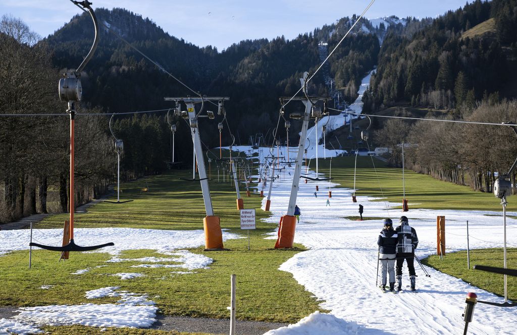 Pelancong di Lenggries, Jerman, bermain ski di jalur yang hanya tersisa sedikit pada 28 Desember 2022. Tempat wisata ski di sekitar Alpen dan Pyrenee kekurangan salju tahun ini. 