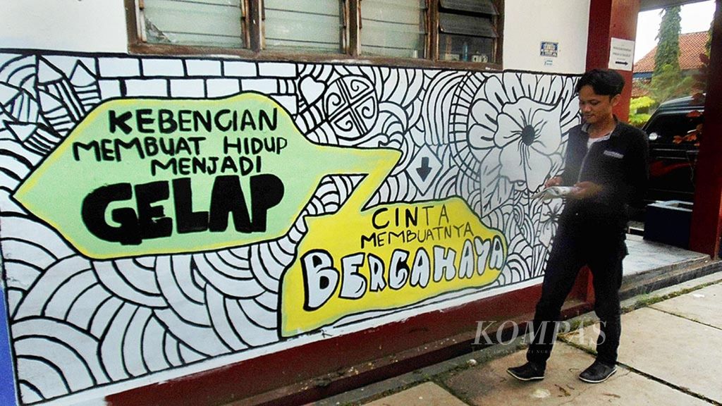 Warga melintasi dinding yang berisi mural tentang perdamaian di kawasan Institut Studi Islam Fahmina, Kota Cirebon, Jawa Barat, Senin (10/4/2017). Mural terebut mengajak masyarakat untuk tidak menebar kebencian dan melakukan kekerasan.