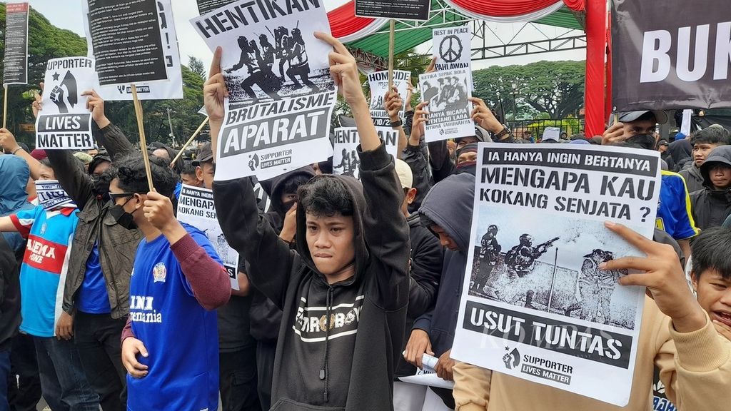 Sejumlah poster bernada tuntutan mewarnai aksi oleh seribuan Aremania di depan Bala Kota Malang, Jawa Timur, Kamis (27/10/2022). Mereka menuntut proses hukum yang adil terkait Tragedi Kanjuruhan yang menewaskan 135 orang dan ratusan lainnya terluka itu.