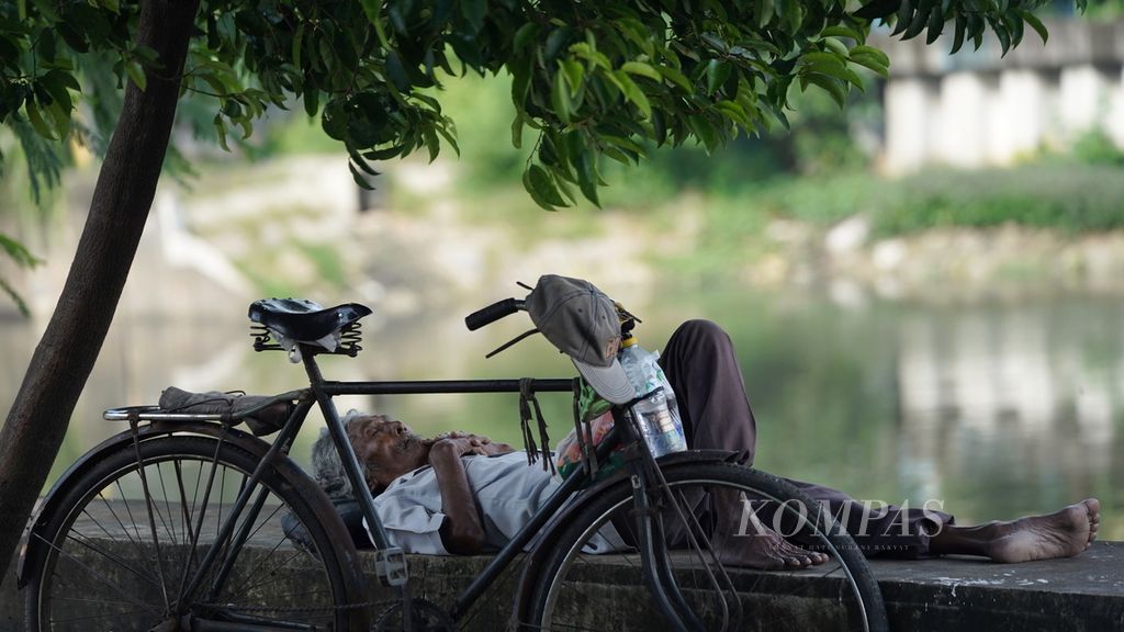 Warga lansia terlelap di samping sepeda ontelnya di Jalan Inspeksi Kali Sunter, Kelurahan Rawa Badak Utara, Koja, Jakarta Utara, Senin (6/3/2023). Tidur bukan hanya meningkatkan daya tahan tubuh, tetapi juga menjaga konsentrasi dan suasana hati. 