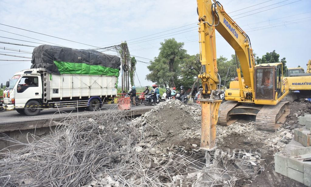 Truk melintasi ruas jalan tersisa dari Jembatan Ngaglik 1 yang ambles dan sedang dalam proses penghancuran di Kabupaten Lamongan, Jawa Timur, Rabu (30/3/2022).