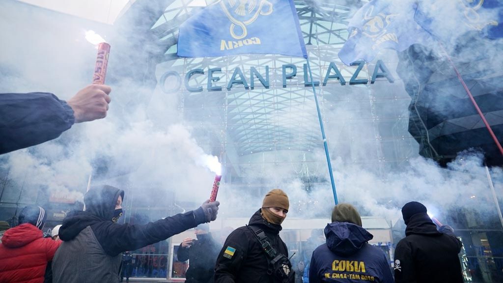 Aktivis kelompok sayap kanan Ukraina menyalakan suar saat memblokade pusat perbelanjaan besar "Ocean Plaza" milik pebisnis Rusia di Kiev, Ukraina, Selasa (27/11/2018). Tindakan itu wujud protes dari penahanan pelaut dan kapal Ukraina. 