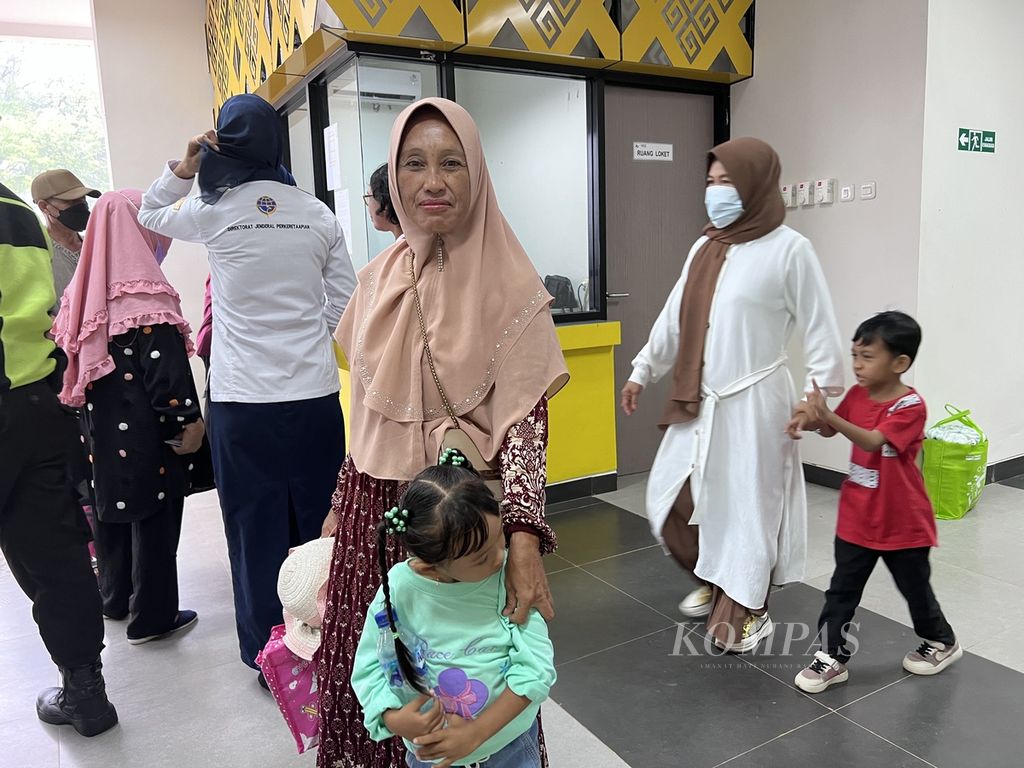 Marsani (55) bersama cucunya menunggu di depan loket tiket di Stasiun KA Mangilu di Pangkep, Sulawesi Selatan, Rabu (9/11/2022). Dia mengikuti perjalanan dalam rangkaian ujicoba KA Pangkep-Barru.