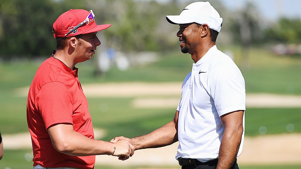 Tiger Woods (kanan), legenda hidup golf dari Amerika Serikat, bersalaman dengan Marcus Armitage, pegolf Inggris, yang mengidolakan Woods, menjelang Omega Dubai Desert Classic di Emirates Golf Club, Uni Emirat Arab, Selasa (31/1).