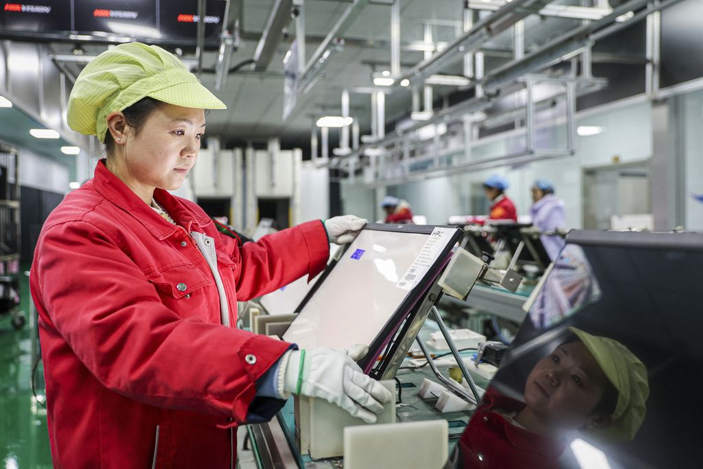 Seorang karyawan bekerja pada lini produksi monitor LCD di sebuah bengkel di Ruichang, Provinsi Jiangxi, China, pada 26 Februari 2024.