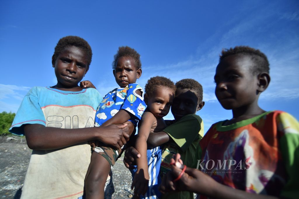 Anak-anak suku Kamoro atau suku laut asli Kabupaten Mimika di sekitar rumah sementaranya di Pomako, Mimika, Papua, Jumat (15/10/2021).  