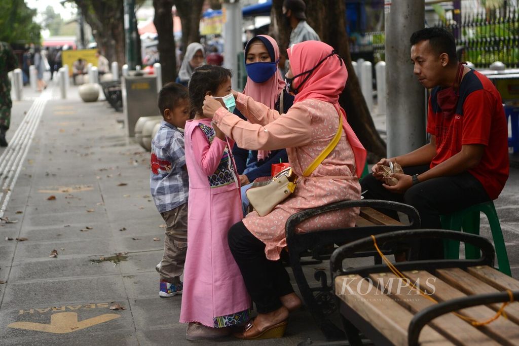 Wisatawan mengenakan masker yang dibagikan polisi dalam kampanye pencegahan penularan Covid-10 di Jalan Malioboro, Yogyakarta, Kamis (10/9/2020). Polda DIY menggelar pembagian 200.000 masker dan kampanye pencegahan penularan Covid-19 di kawasan itu. 