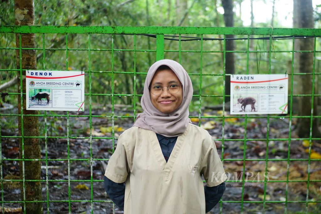 Drh Afifah Hasna, dokter hewan di Anoa Breeding Center (ABC) Manado, pusat pengembangbiakan anoa di Sulawesi Utara, berpose di depan kandang dua anoa bernama Denok dan Raden, Rabu (5/7/2023). Afifah adalah dokter hewan pertama yang berhasil membantu kelahiran anoa dataran rendah (<i>Bubalus depressicornis</i>) dengan operasi caesar.