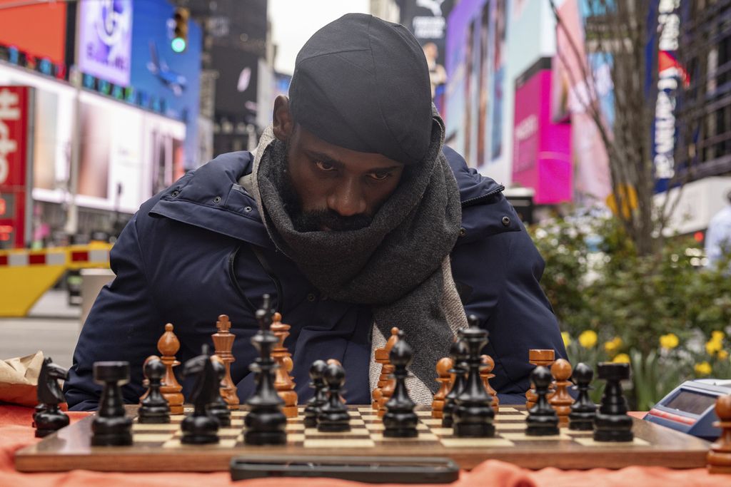 Tunde Onakoya, master catur dan pegiat pendidikan anak asal Nigeria, bermain catur maraton di Times Square, New York City, AS, Jumat (19/4/2024). Ia memecahkan rekor dunia catur maraton, Sabtu (20/4/2024), dalam permainan untuk menggalang dana bagi pendidikan anak-anak di Afrika. 