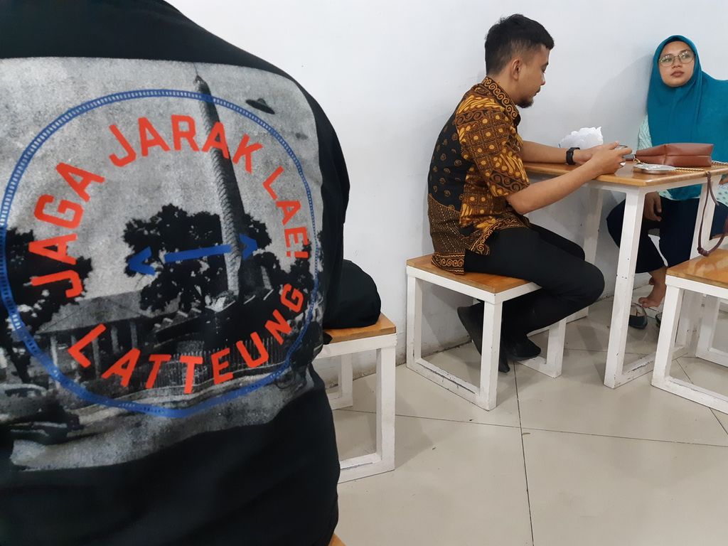 Pendiri toko kaus Tauko Medan Fathraria (kiri) menggunakan kaus bertuliskan cakap anak Medan di Medan, Kamis (12/8/2021).